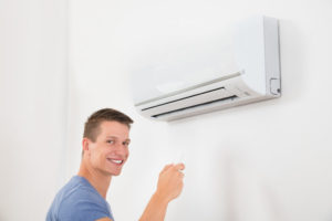 Man Holding Remote To Ductless System