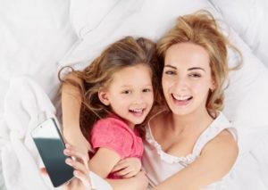 Mom And Daughter Cuddling In Bed